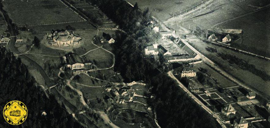 Luftaufnahme des Tierpark Hellabrunn aus dem Jahr 1920. oben rechts kann man die mitten ins Grüne gebaute Schleife Harlaching an ihren Oberleitungsmasten erkennen