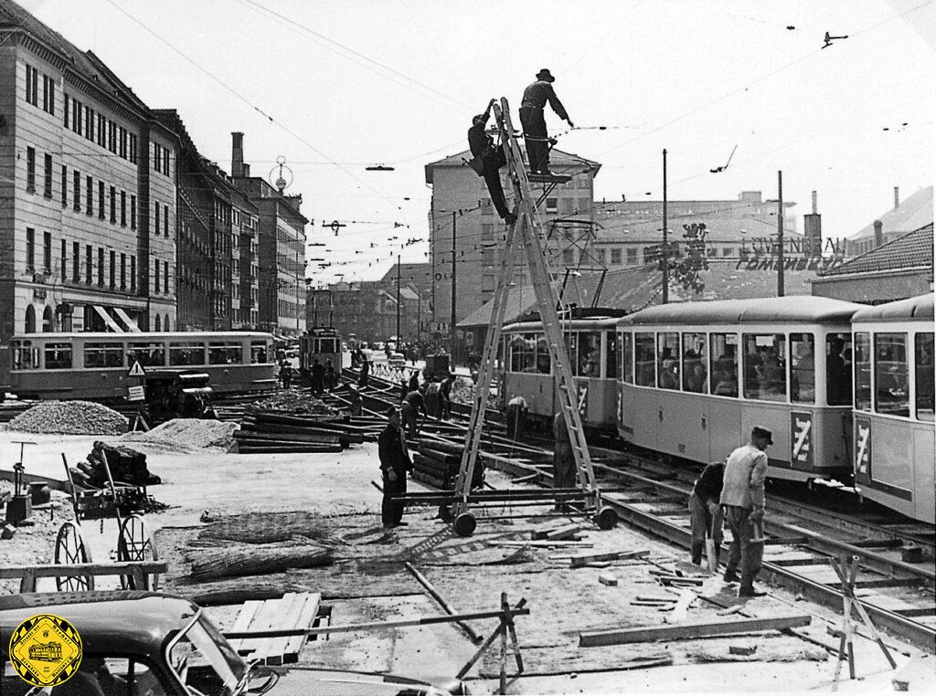 Am 24.6.1955 passiert der E-Triebwagen 583 an der Kreuzung Bayer- /Schillerstraße auswärts die Baustelle. Deutlich sieht man die neue Lage der Schienen mehr zur Mitte des Bahnhofplatzes.