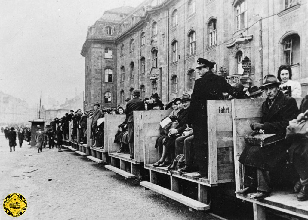 Die Kriegszerstörungen in der Stadt und bei der Trambahn waren sehr groß und auch der Trambahnbetrieb konnte nur notmäßig täglich angepaßt stattfinden. Durch die Arnulfstraße führte eine schmalspurige Schuttbahn, die auch beim Erliegen des Trambahnverkehrs in den Kriegsmonaten als Trambahnersatz mit Feldbahn-Dampflokomotiven genutzt wurden.
Ein Zug 1944 der Bockerlbahn römisch I vom Steubenplatz unterwegs durch die Arnulfstraße zum Hauptbahnhof.