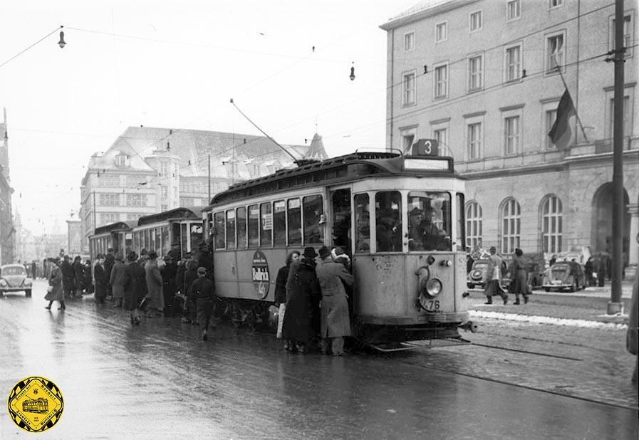 Die Trambahnen sind in der Nachkriegszeit die Schlagader des Personenverkehrs und nicht nur in der Hauptverkehrszeit heiß begehrt wie hier die Linie 3 an der Haltestelle am Hauptbahnhof-Nord in der Arnulfstraße Richtung Romanplatz.