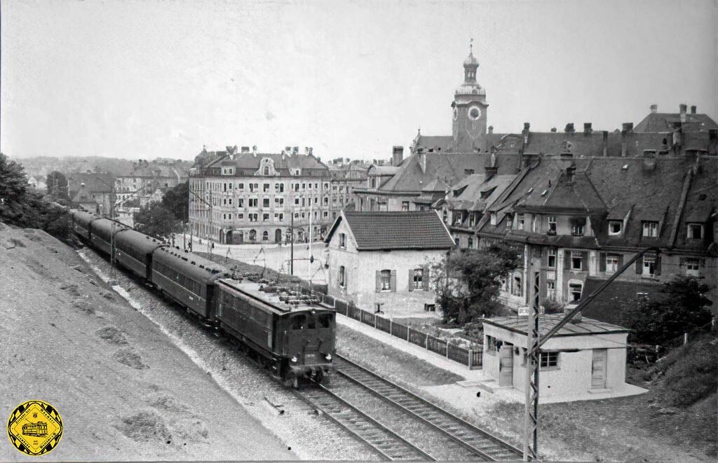 Seit dem 15. März 1871 über die Jahrzehnte bis heute ist der Kolumbusplatz geprägt durch die Eisenbahnbrücke des Münchner Südrings. Hier sehen wir den Dampflokbespannten Orientexpress auf dieser Brücke und nach der Elektrifizierung ab dem 3. Januar 1927 dieser Bahnstrecke einen Schnellzug nach Wien.