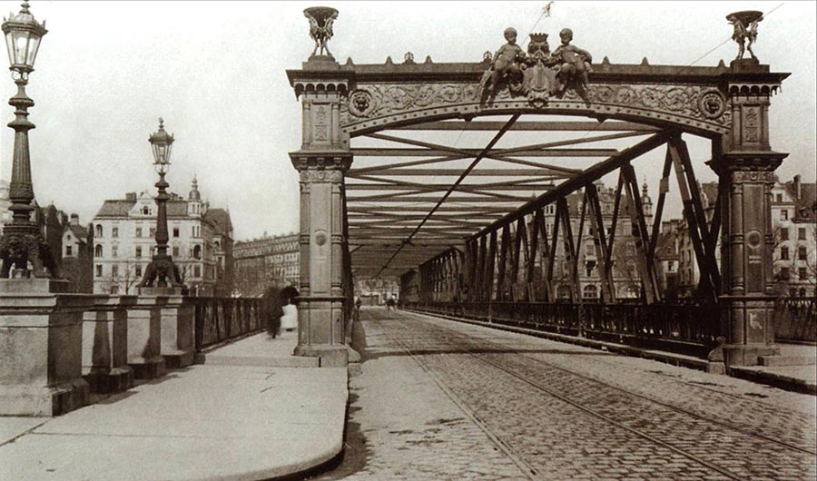Zur Jahrhundertwende waren gerade mal 100 Autos in München zugelassen und so waren es meist Fuhrwerke, die sich den Platz mit der Trambahn auf der Wittelsbacher Brücke teilen mussten. Langsam wurde aber diese Brücke zu klein.