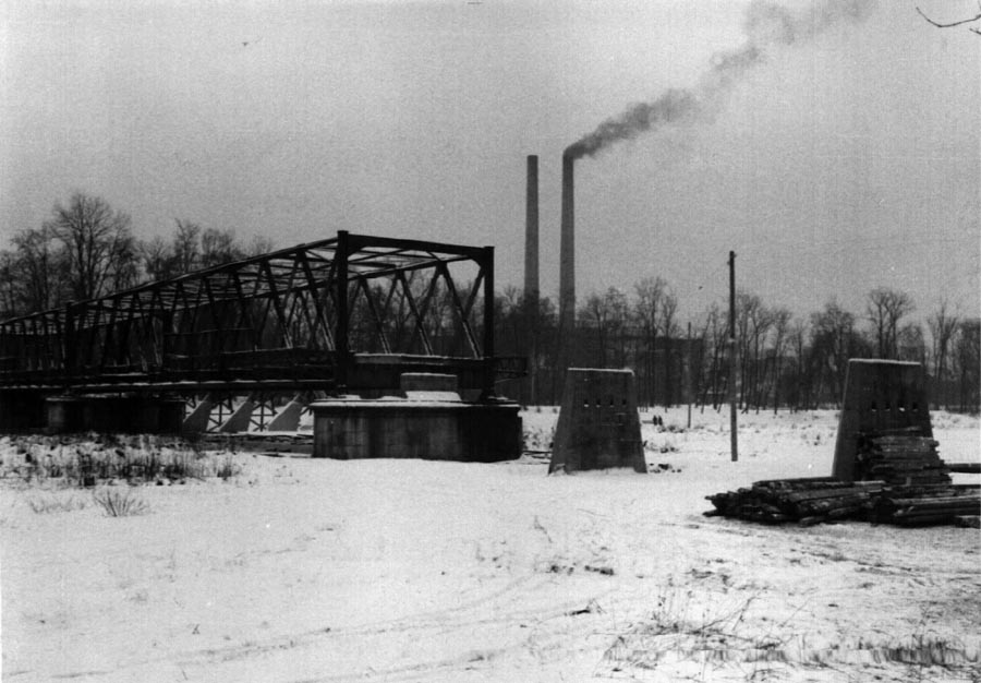 Nachdem diese Brücke 1943 im Zweiten Weltkrieg schwer beschädigt worden war, wurde 1948 provisorisch ein Fußgängersteg über die zerstörten Stellen errichtet. Im Hintergrund sieht man das Kraftwerk an der Schäftlarnstraße. Hier ist der provisorische Holzsteg schon abgebaut.