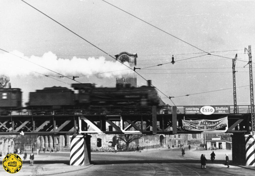 Der 2.Weltkrieg ist vorbei und die Linie 17 bleibt dem Kolumbusplatz treu. Es gab sehr weitgehende Zerstörungen am Kolumbusplatz, aber die Bomben, die wohl die Bahnstrecke und ihre Brücken treffen sollten verfehlten ihr Ziel und zerstörten das Schulgebäude komplett, wie man im Hintergrund sieht. Die Brücken blieben erhalten. Wegen der geringen Höhe der Brücke wurde sie von den Amerikanischen Truppen weiß markiert und die Pfeiler schraffiert. So fuhren ab dem 6.Oktober 1947 wieder Trambahnen unter den Brücke am Kolumbusplatz.