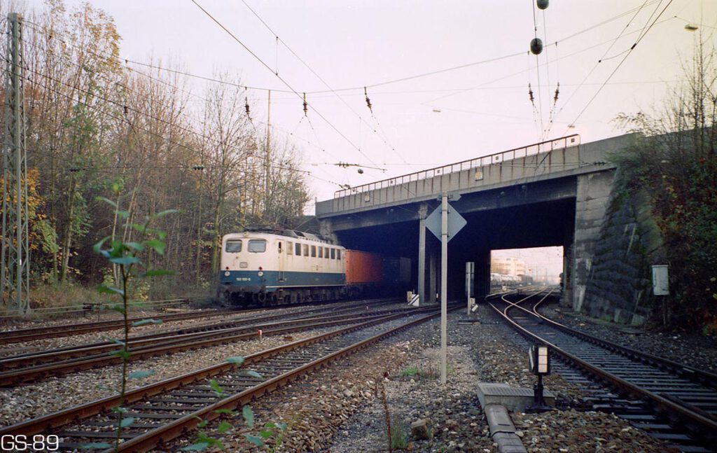 Die Einmündung in den Südring Ende Oktober 1989 mit der Brücke der Landsbergerstraße über die 4-gleisige Eisenbahnstrecke, Blickrichtung nach Osten. Vom Heimeranplatz kommend erreicht die BR150 100-6 (Bw Nürnberg 2) München-Laim Rbf