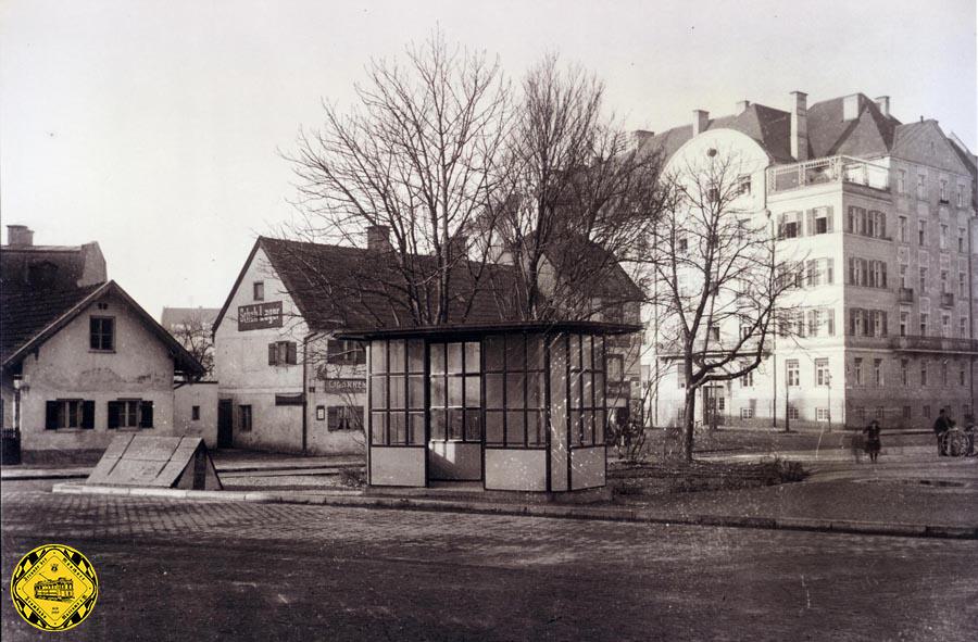 Der Rotkreuzplatz bekam 1915 sein erstes eher schlichtes Wartehäuschen. Zur Orientierung: im Hintergrund steht jetzt der Kaufhof, das große Haus rechts ist auch heute noch das Eckhaus Wendl-Dietrich-Straße/Winthirstraße. Die Halle bestand bis 1929. 