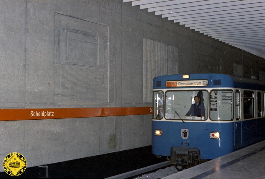 Der viergleisige Kreuzungsbahnhof Scheidplatz im Stadtteil Schwabing-West ist wie die anderen Bahnhöfe der Olympialinie U3 in damals beliebter Sichtbetonoptik ausgeführt. Geplant wurde er vom U-Bahn-Referat, die Sichtbetonreliefs an den Bahnsteigwänden wurden von Waki Zöllner gestaltet