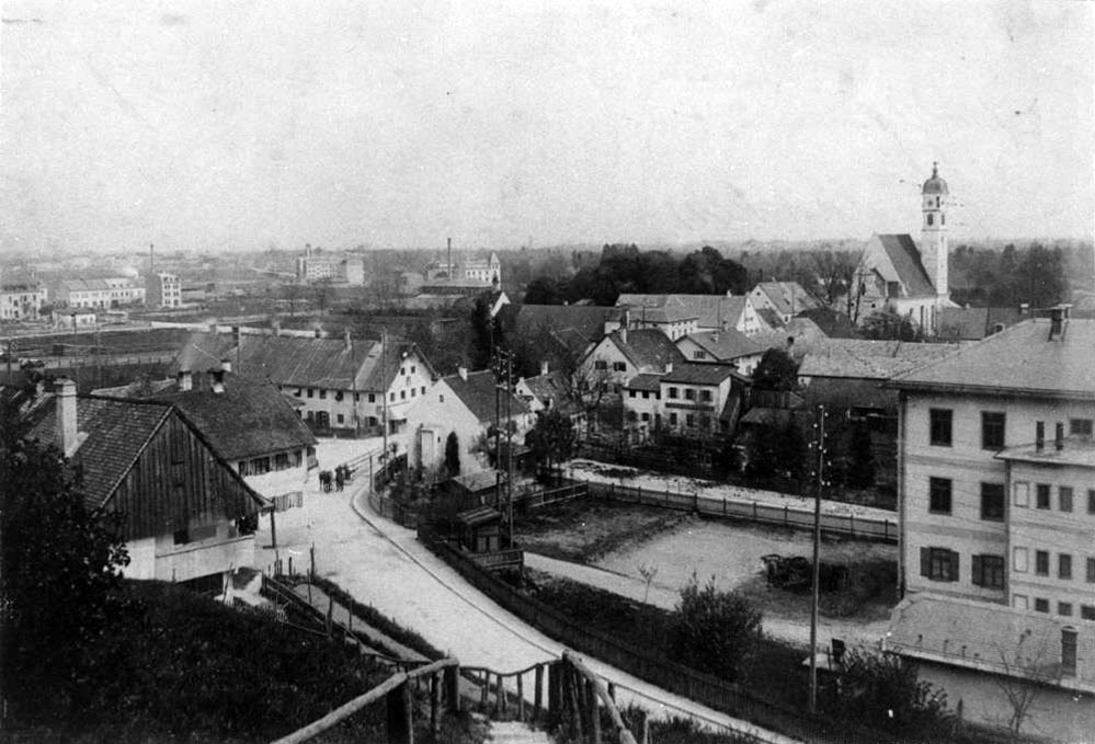 Dieses Bild mit dem Blick von Schmiedberg runter auf das Dorf Sendling von 1898 zeigt die Stromleitungen, die dort schon die Häuser verbanden, Werkstätten versorgten und die Straßen beleuchteten. Dieses Bild ist auch insofern sehr interessant, weil man im Hintergrund das gerade neu errichtete Kraftwerk an der Schäftlarnstraße erahnen kann. 