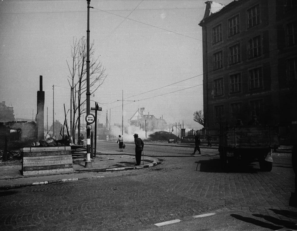 Unser Bild vom 20.November 1945 zeigt rechts das Schulhaus und die Ruinen auf dem Platz der ehemaligen Kochelbräu an der Implerstraße. Und wenn man ganz genau schaut, sieht man sogar die rot/weißen Barken, zwischen denen der Bahnübergang ist. 