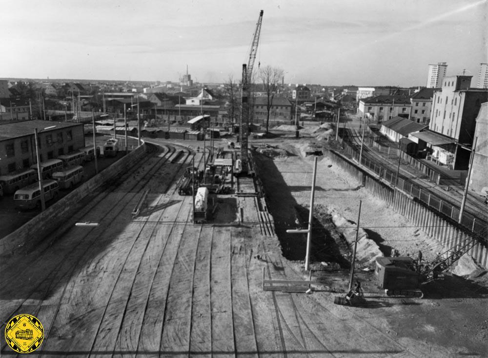 Am 30.November 1960 wurde der Bau der neuen Wartungshalle im Betriebshof an der Hofmannstraße dokumentiert und dabei auch rechts das Industriegleis zum ebenfalls gerade im Bau befindlichen Heizkraftwerk im Hintergrund abgelichtet. Links kann man die Abstellfläche mit den O-Bussen erkennen. 
