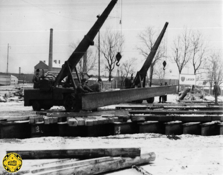 Während im letzten Schnee des Februar 1951 oben schon die Stahlträger für die neue Brücke angeliefert wurden, werden unten schon die Fundamente für die Mittelpfeiler erstellt.