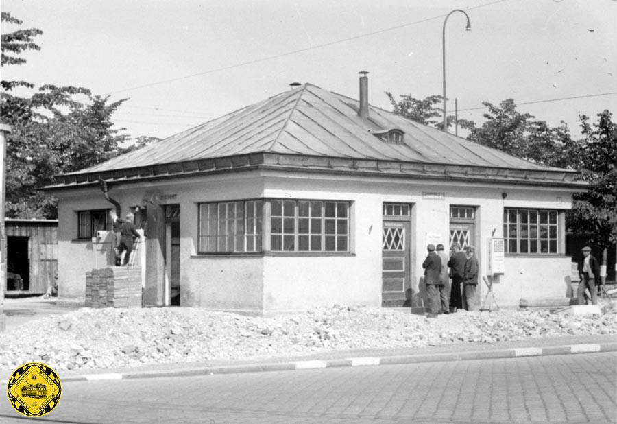 Das Stationshaus am Leonrodplatz mit seiner  Südostseite zeigt den Bau der Sichtschutzwand vor den Toiletten- und Pissoireingängen im Juni 1940.
