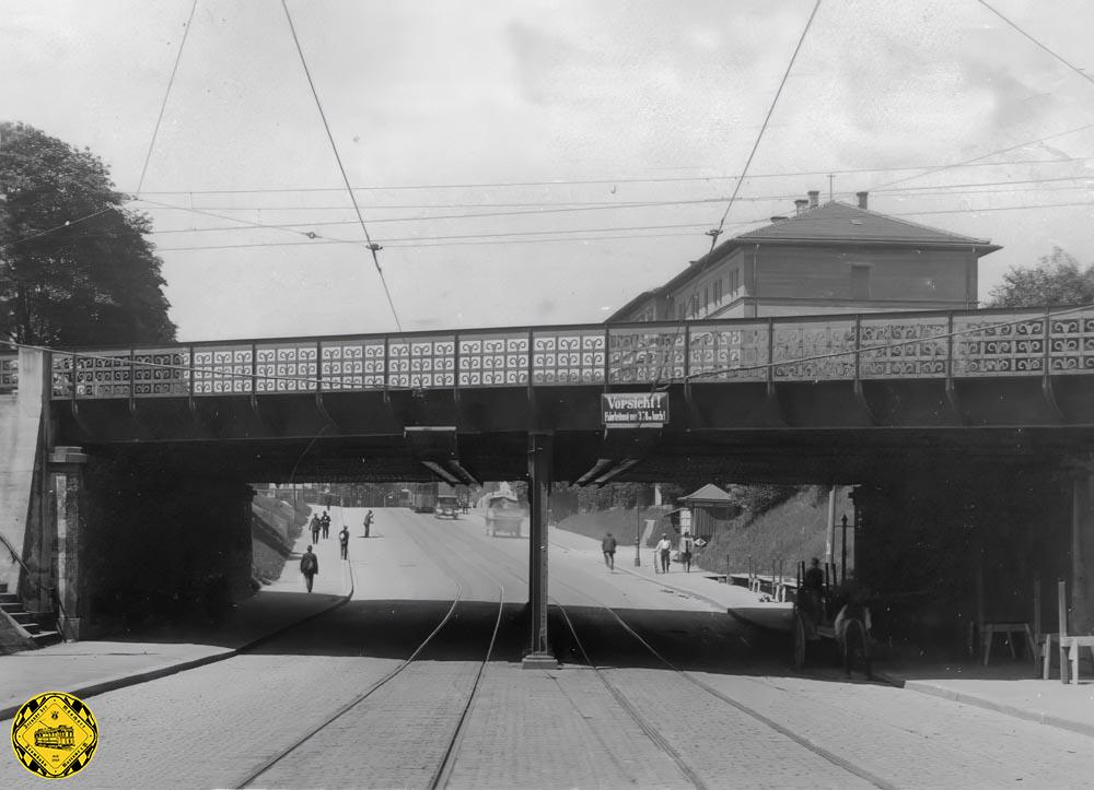 Diese Unterführung wurde für einfachen Fuhrwerksverkehr mit Gehwegen an beiden Seiten und einer Trambahn in der Mitte gebaut. Mit der Zeit aber wurde diese Unterführung etwas zu schmal. Im Jahr 1925 kann man gut das alte Geländer der Brücke sehen, das bald danach ersetzt wurde. Die Bahnstrecke hat schon Oberleitung, da im selben Jahr diese Simbacher Bahnstrecke elektrifiziert wurde.