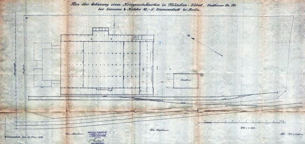 Der Lageplan von 1918 des Geländes der heutigen Hauptwerkstätte, als es als Kriegsmetallwerk von Siemens gebaut wurde, zeigt die beiden großen ersten Gebäudekomplexe, die Betriebshalle und rechts das Kesselhaus.