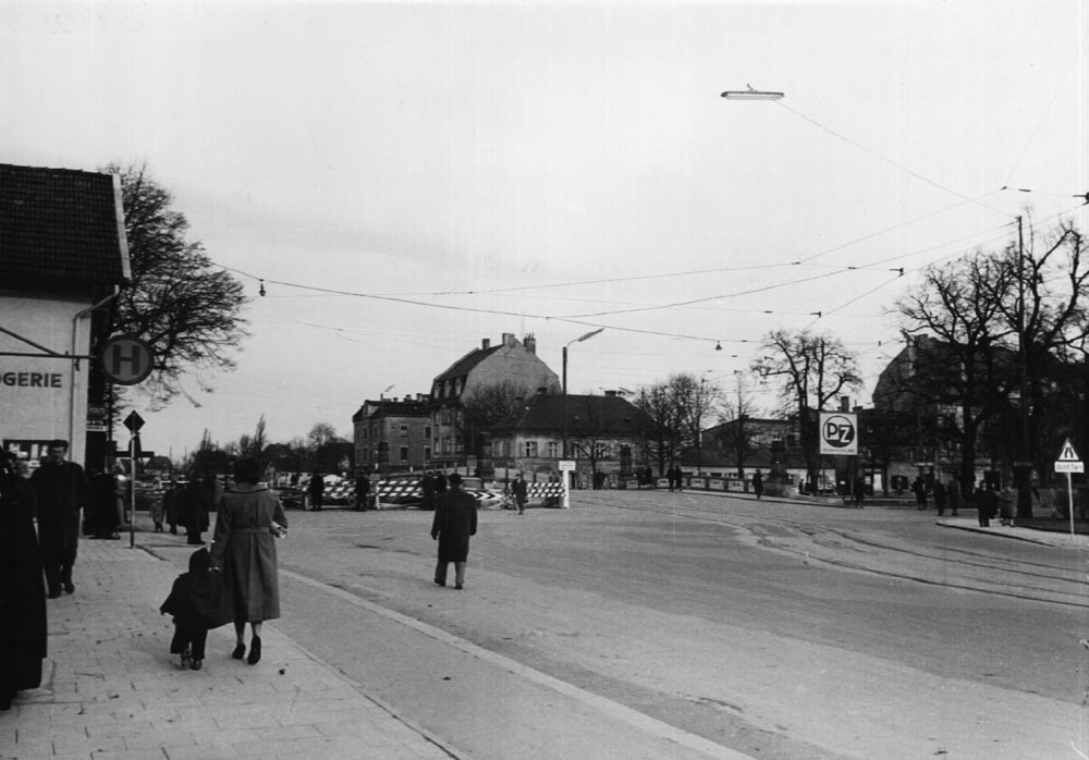 Wenige Jahre später 1956 wurde die Brücke wesentlich verändert und erneut verbreitert auf 33 m. Am 22. Januar 1956 wurden die ersten Baustellen-Absicherungen aufgestellt, wir blicken aus der Nothburgastraße auf die Brücke.