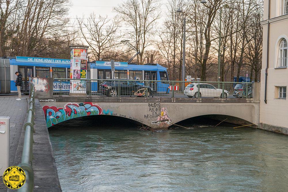 Schon 1804, als die Bogenhausener Brücke als Vorgängerbau der Max-Joseph-Brücke errichtet wurde, wurde in deren Verlängerung eine einfache Holzbrücke über den Eisbach errichtet. Sie entstand nah den Plänen des Hofkammerrat und Wasser-, Brücken- und Straßenbau-Kommissar Adrian von Riedl.
Sie bestand über hundert Jahre bis 1906 und wurde dann durch eine Steinbrücke ersetzt. 1978 wurde die heutige Brücke errichtet. Die Spannweite beider Bögen beträgt 8,50 m, die Gesamtlänge der Brücke ist 17 m. Über die Brücke führt eine Straße mit Parkstreifen, Gehwegen und einer Straßenbahntrasse in der Mitte. Daraus ergibt sich eine Gesamtbreite der Brücke von 27,30 m.