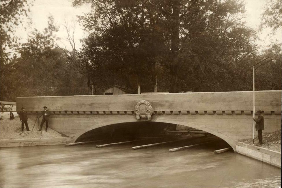 Auf dem Bild aus dem Jahr der Fertigstellung 1906 kann man noch die Fundamente der engstehenden Stützen der alten Holzbrücke erkennen