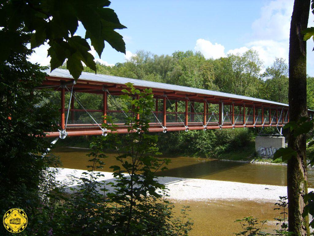 Die wiederaufgebaute Brücke im Mai 2006. Die neue Fachwerkträgerbrücke ist eine Holzkonstruktion mit Stahlguss-Knoten. Mit 96 m Länge aufgeteilt in Spannweiten von 10,52 m, 34 m und nochmal 10,52 m können Geh- und Radweg auf einer Breite von 3,50 m die Isar hier überqueren. 