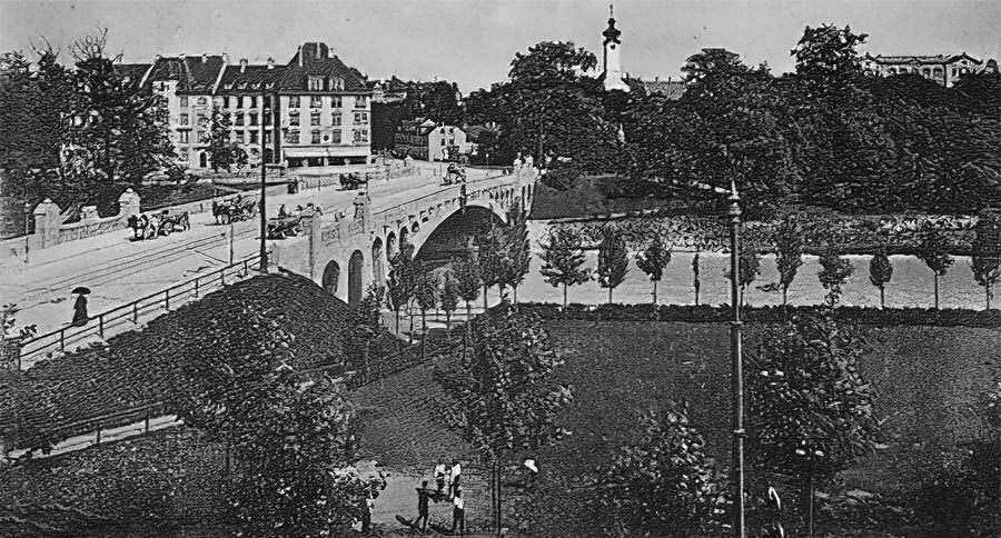 Die Max-Joseph-Brücke von Norden gesehen mit dem Gebäude des Turnvereins am Isarufer damals.