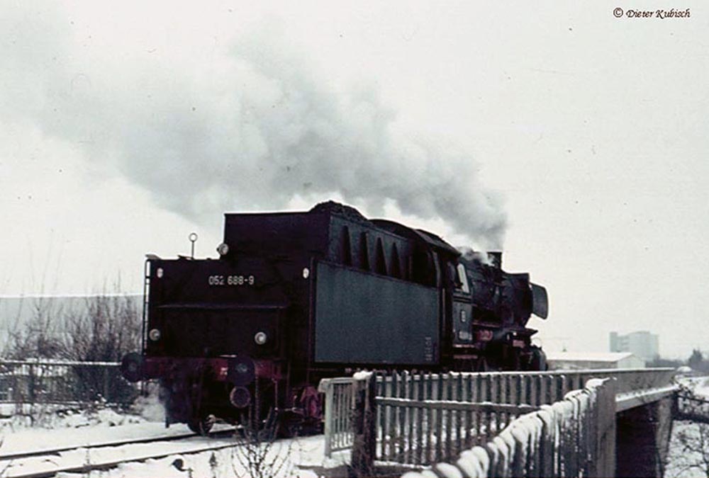 Im Winter 1969 hat die Dampflok BR 52 einen neuen Kohlezug zum Güterbahnhof Schwabing gebracht. Hier wird er jetzt meist in Gruppen von 3 Wagen aufgeteilt. Die Lokomotive steht gerade auf der brücke über die Schenkendorfstraße, heute der Mittlere Ring.