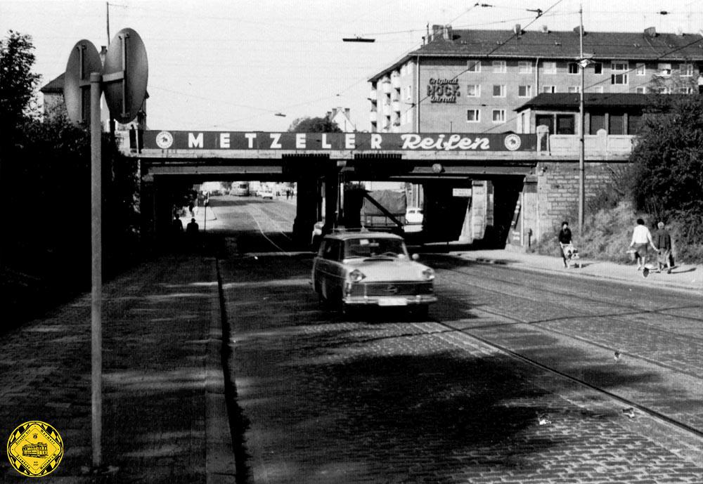 Das Bild aus dem Jahr 1962 zeigt die Forstenriederstraße im Jahr ihrer Umbenennung in Albert-Roßhaupter-Straße. Oben an der Bahn der Vorortbahnhof Mittersendling.