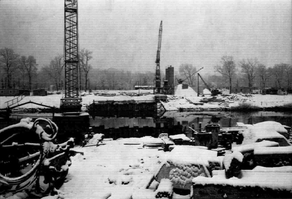 Am 19.Juli 1961 entstand das Bild der Baustelle der neuen Isarbrücke für den späteren Mittleren Ring. Die Fundamente für die Pfeiler sind gesetzt und die Pfeiler für die komplette Fahrbahnbreite von 24 Metern gesetzt. 