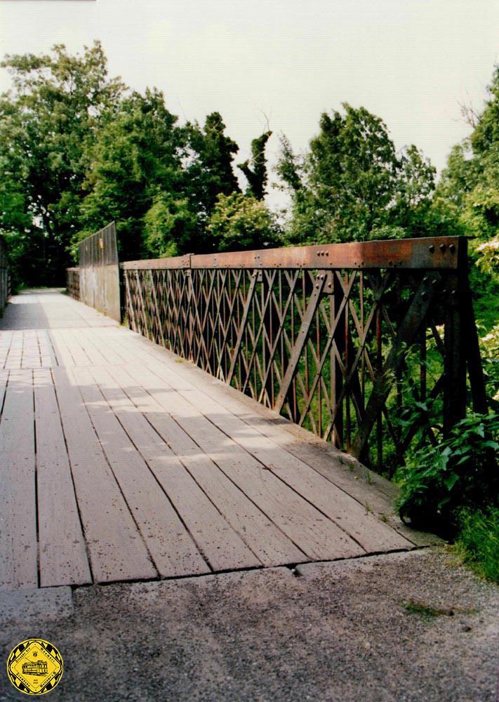 Wir sind im Jahr 1991. Romantiker und Gutachter unterscheiden sich grundlegend bei der Wahrnehmung von Dingen. Der eine sieht eine wundervolle historische alte Brücke, der Gutachter dokumentiert vor allem eines: ein hoher Arbeitsaufwand, um diese Brücke von Grund auf zu sanieren. Die Holzbohlen wurden zwar öfter schon gewechselt, aber der Unterbau ist rostig und das Mauerwerk stark angegriffen.